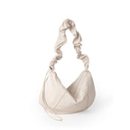 Beige handbag with a textured handle on a white background