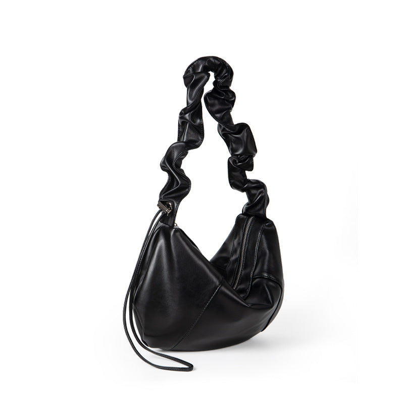 Black handbag with twisted handle on a white background