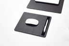 Black mouse pad with a white mouse and pen on 