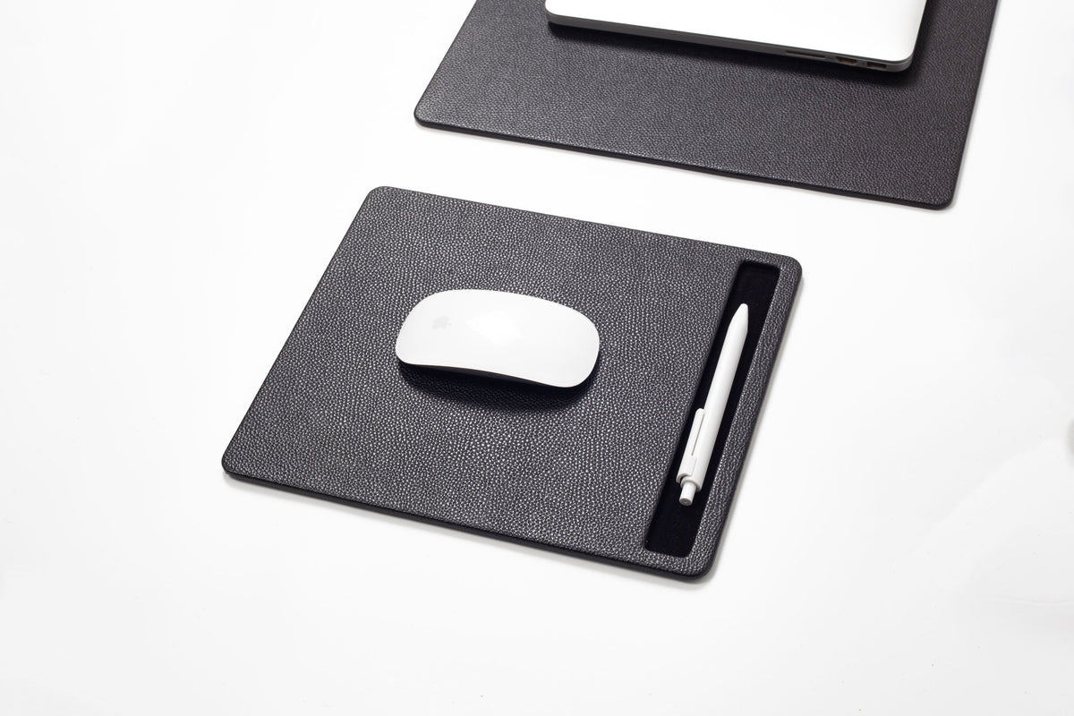 Black mouse pad with a white mouse and pen on 