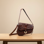 Brown leather handbag with intricate designs on a beige background