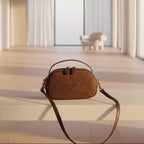 Brown suede handbag on a textured surface