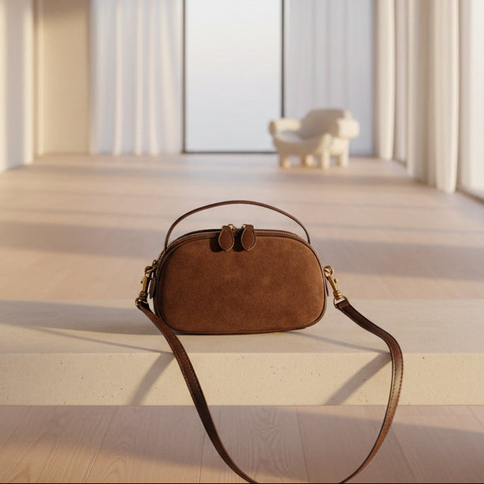 Brown suede handbag on a textured surface
