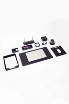 Collection of office supplies including a laptop, tablet, and various small electronic devices