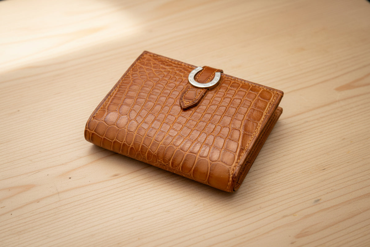Brown crocodile-patterned leather wallet on a light gray background