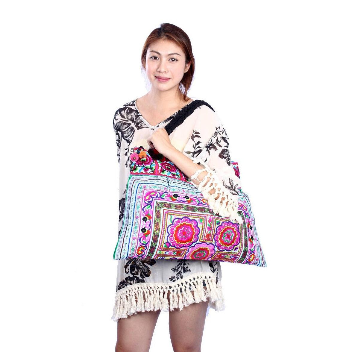 Woman holding a colorful bag with intricate patterns on a white background