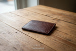 Brown leather cardholder with crocodile texture on a light gray background, featuring the brand 'ORIS'.