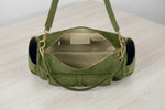 Green handbag with a strap on a light gray background
