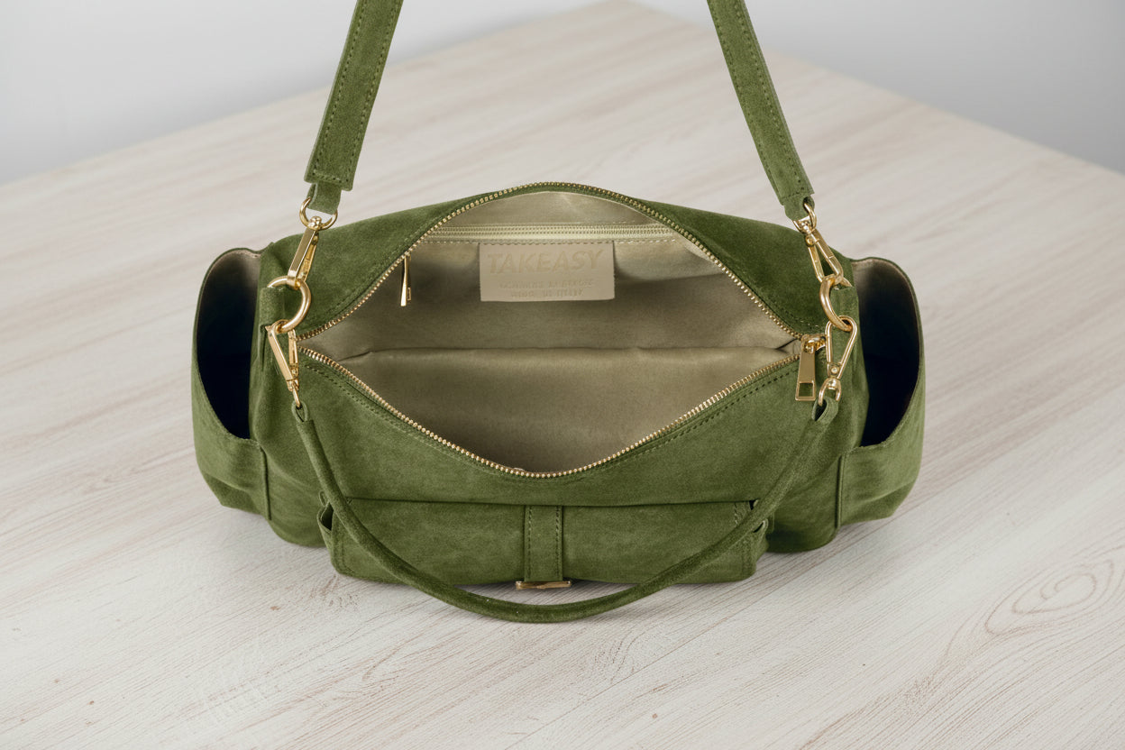 Green handbag with a strap on a light gray background