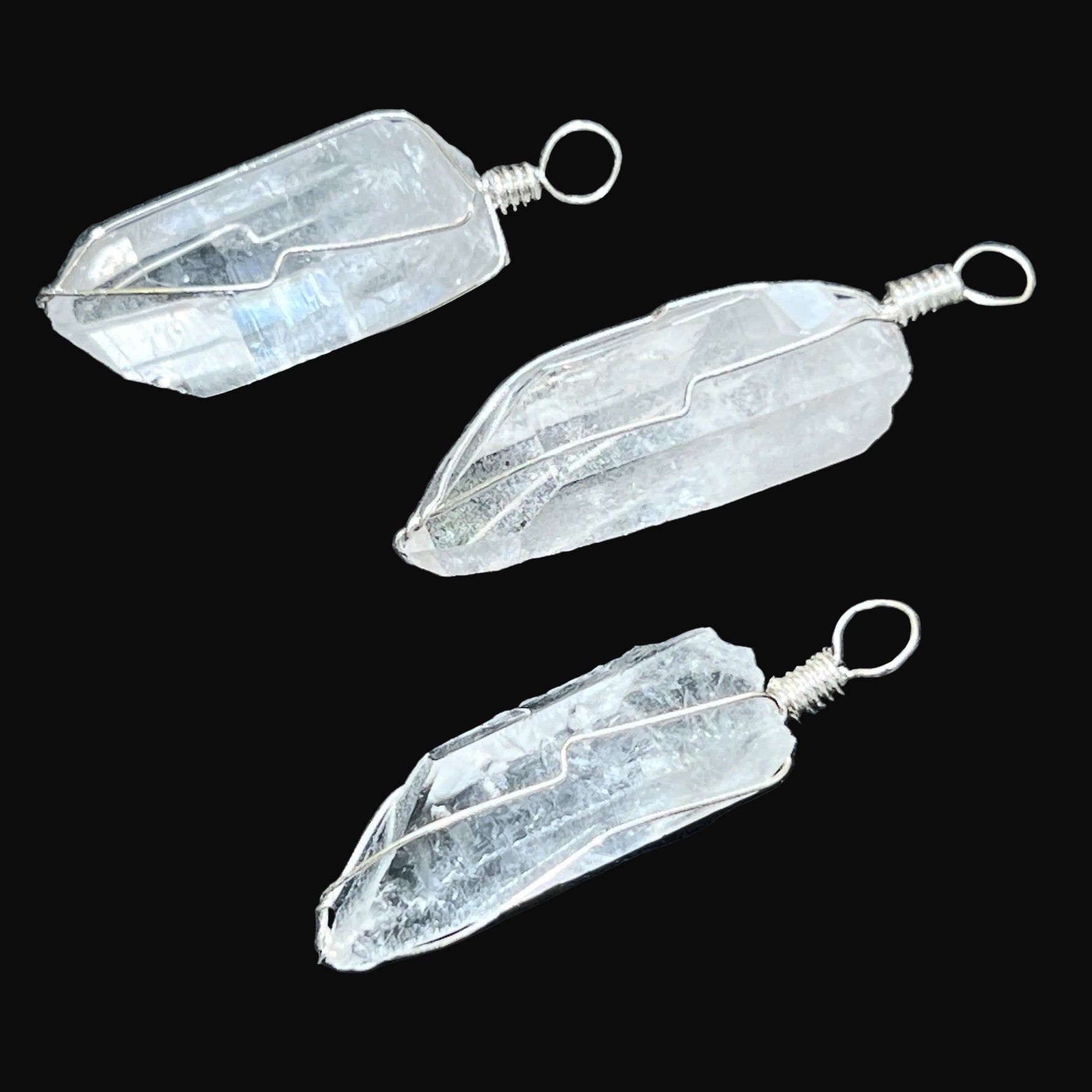 Three crystal pendants on a dark surface