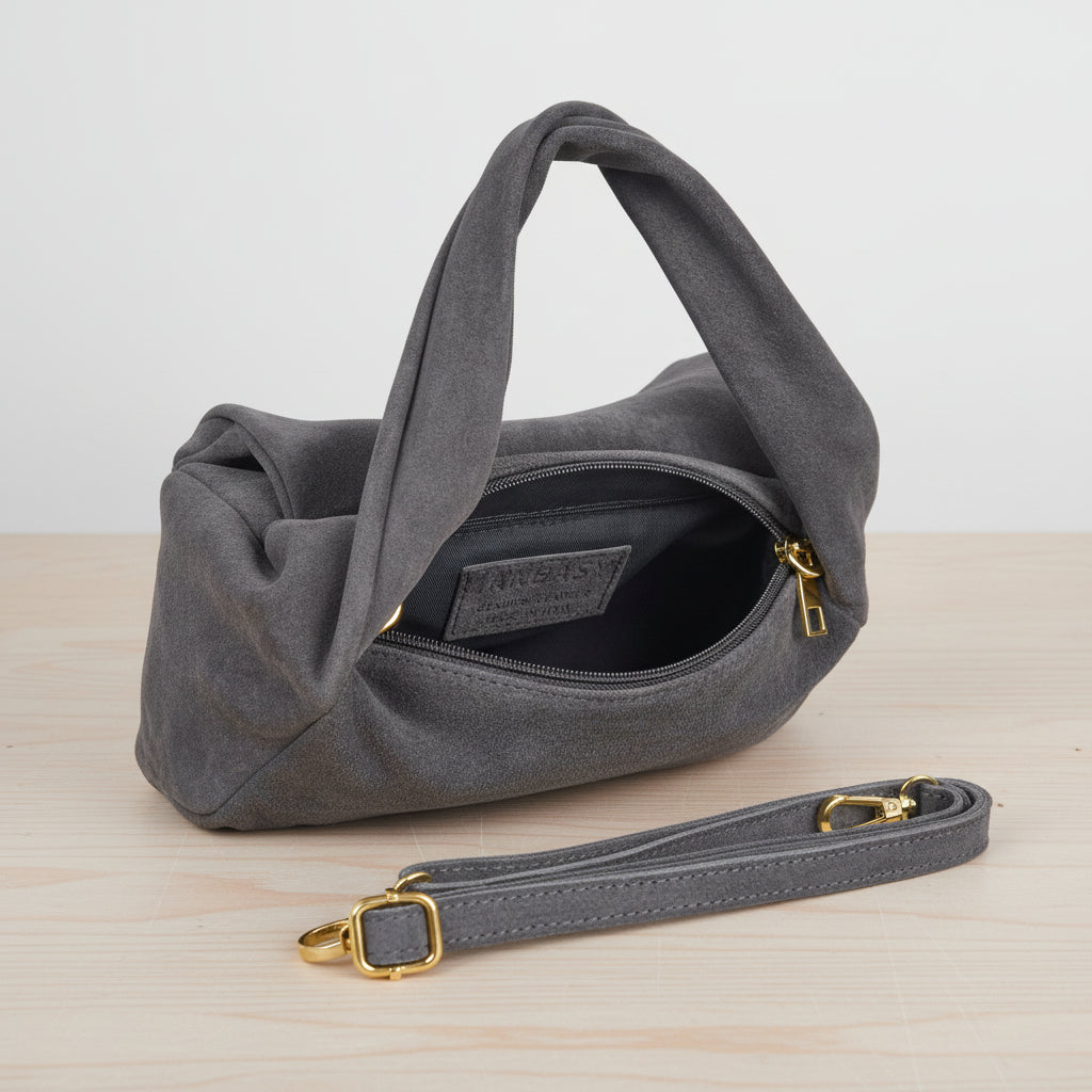Grey handbag with gold accents on a light grey leather