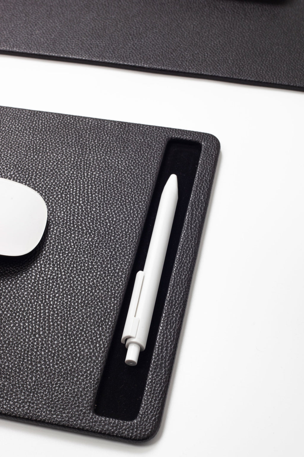 White pen on a black desk pad 