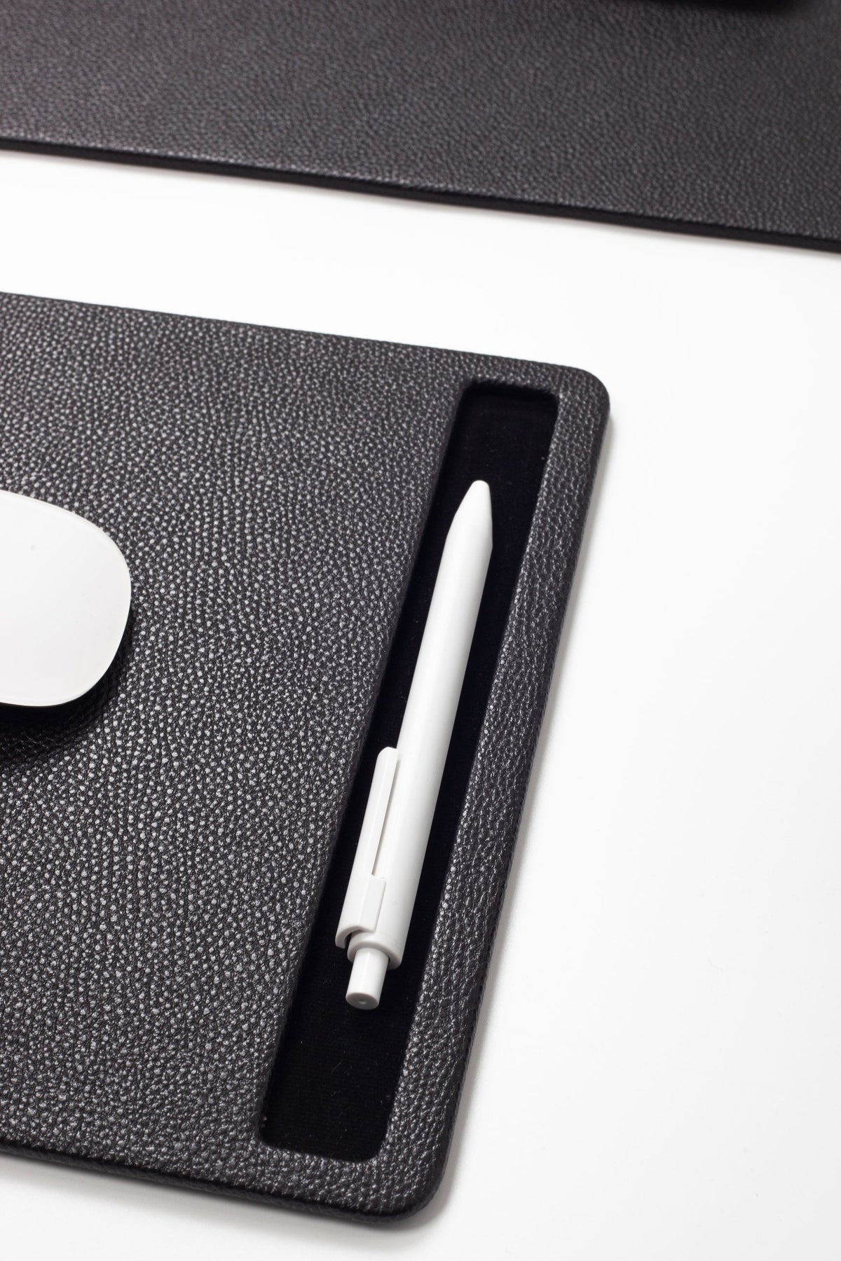 White pen on a black desk pad 