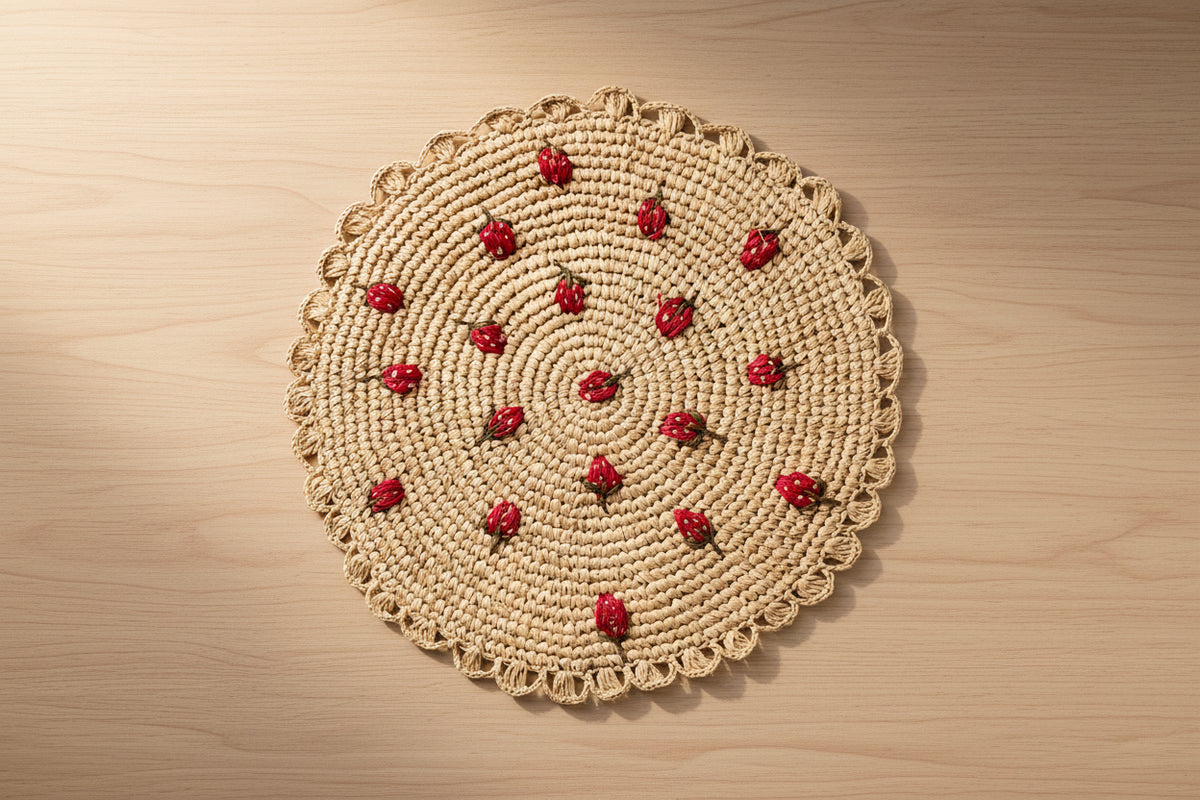 Round woven placemat with red berry patterns on a plain background
