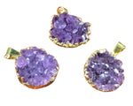 Three purple gemstone pendants with gold frames 