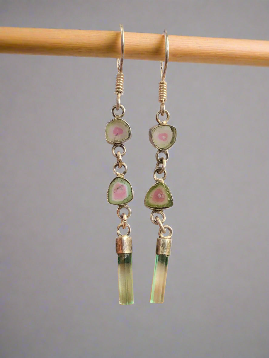 A pair of watermelon slice and tourmaline crystal earrings with silver accents, displayed against a white background.