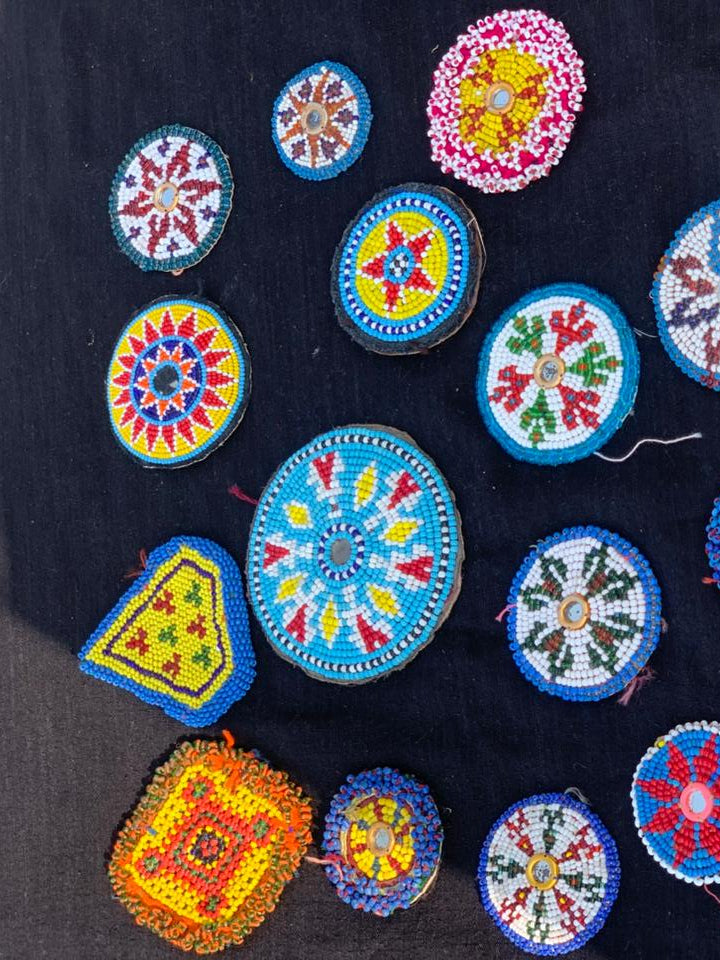 Colorful beaded patches on a dark fabric background