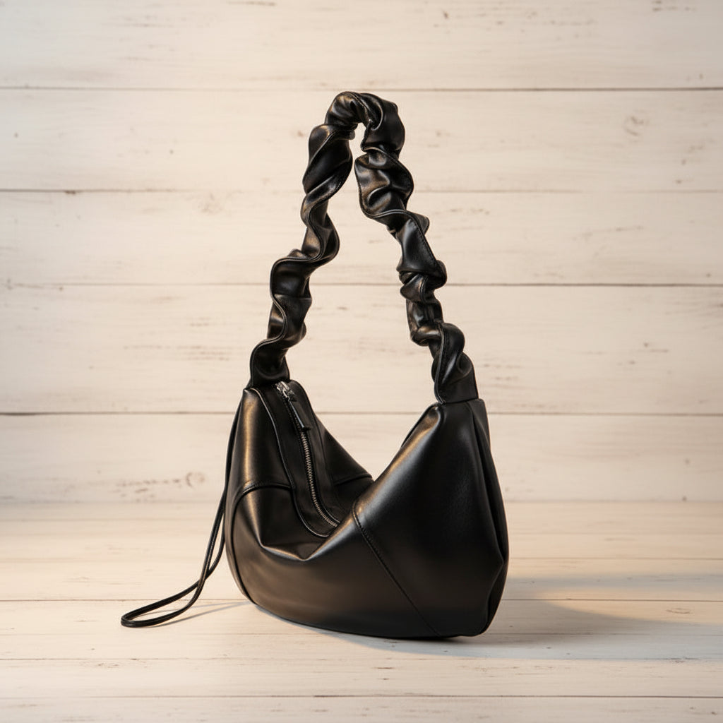 Black handbag with twisted handle on a white background