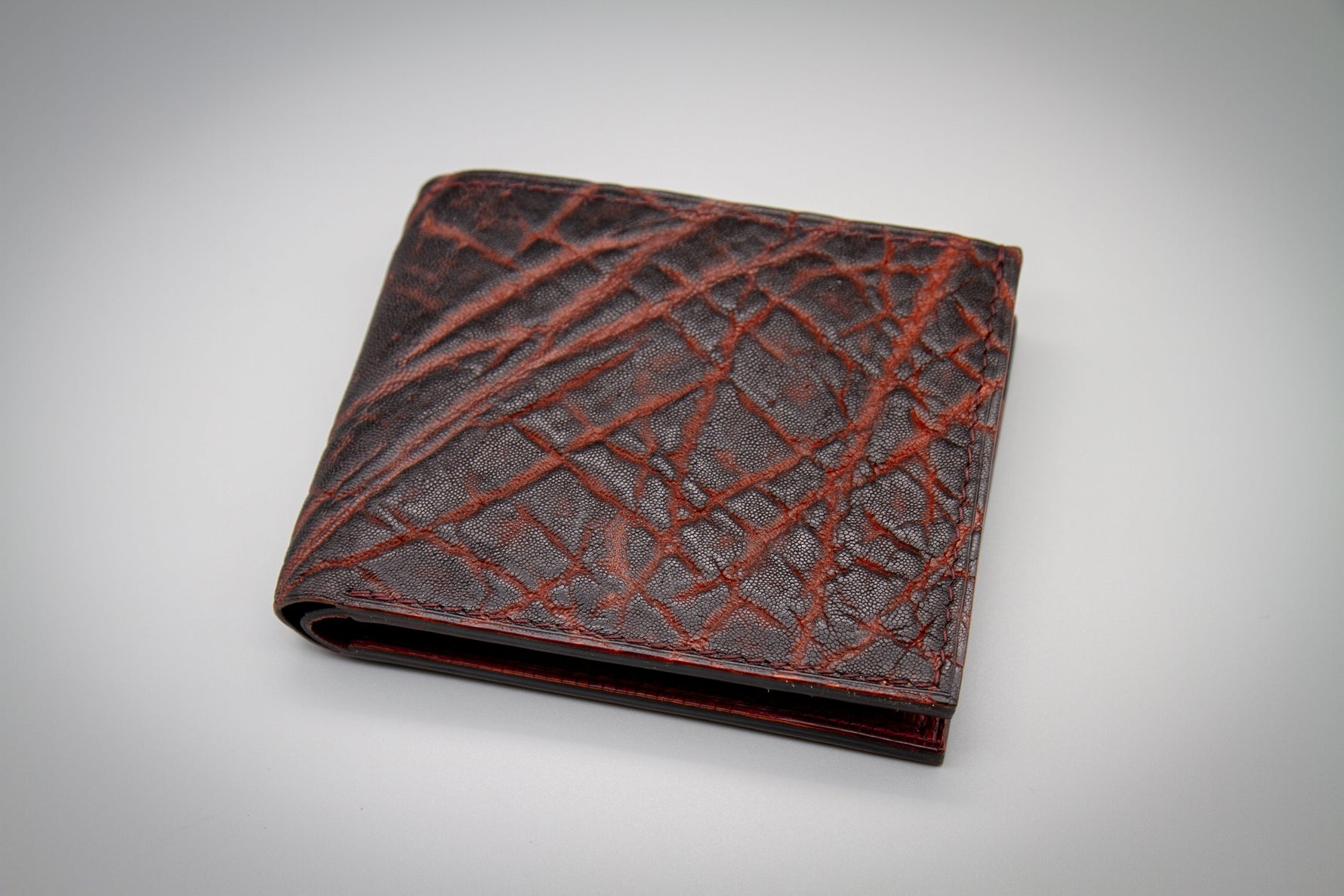 Brown leather wallet with crisscross pattern on a gray background