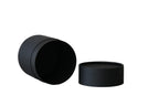Two matte black cylindrical round boxes, one standing upright and one lying on its side