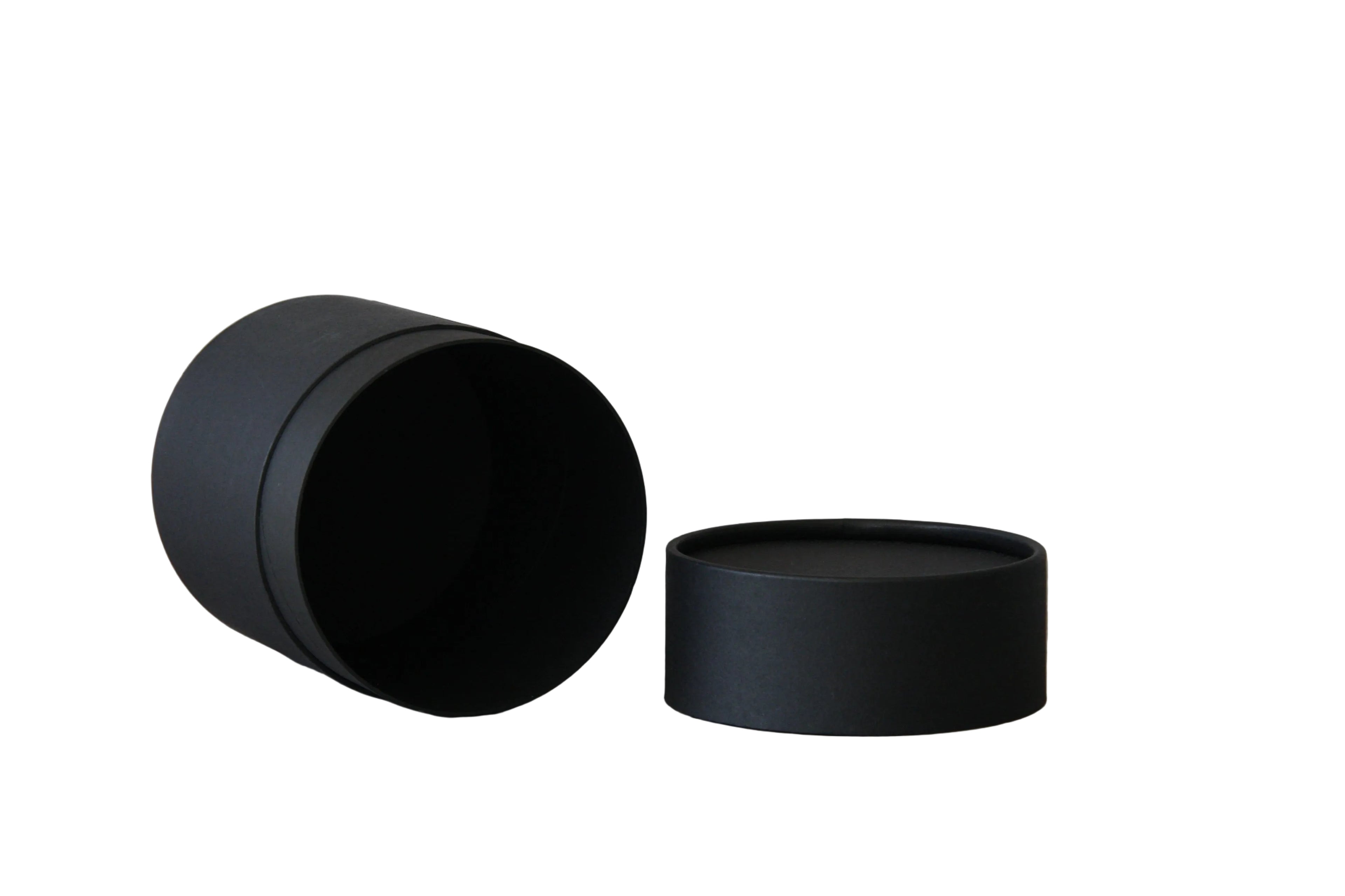 Two matte black cylindrical round boxes, one standing upright and one lying on its side