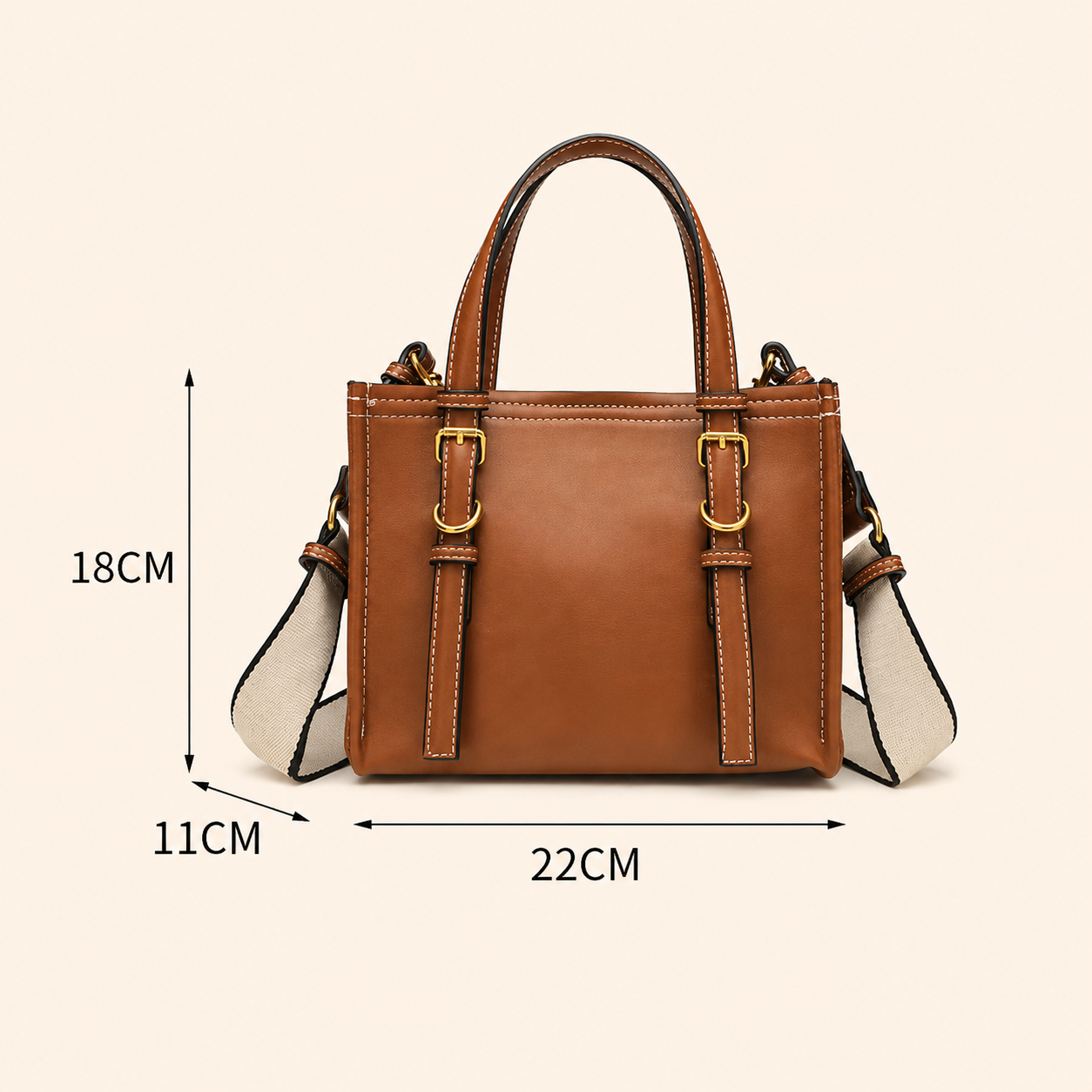 A brown leather handbag with a beige and white shoulder strap, with dimension lines
