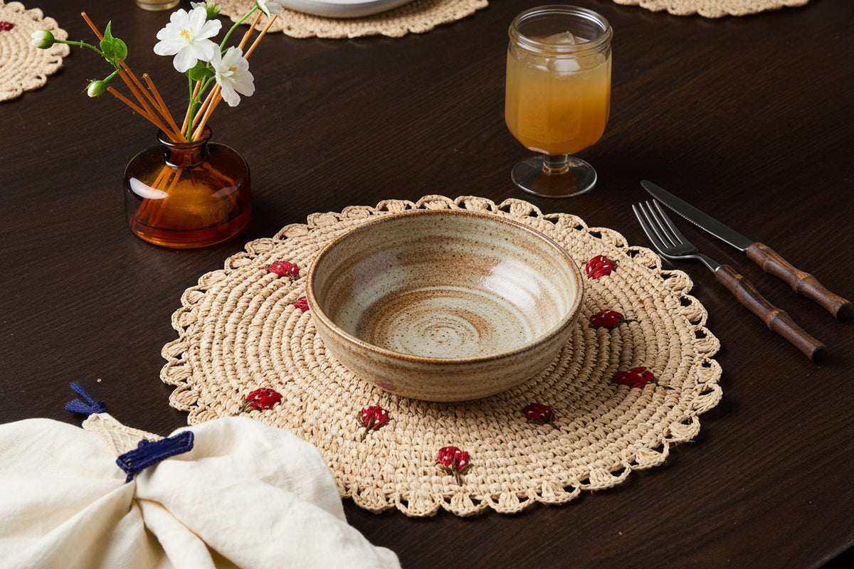 White plate on a woven placemat with a glass of orange juice and cutlery in the background.