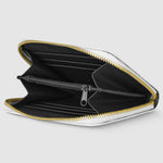 Black wallet with gold zipper on a light gray background