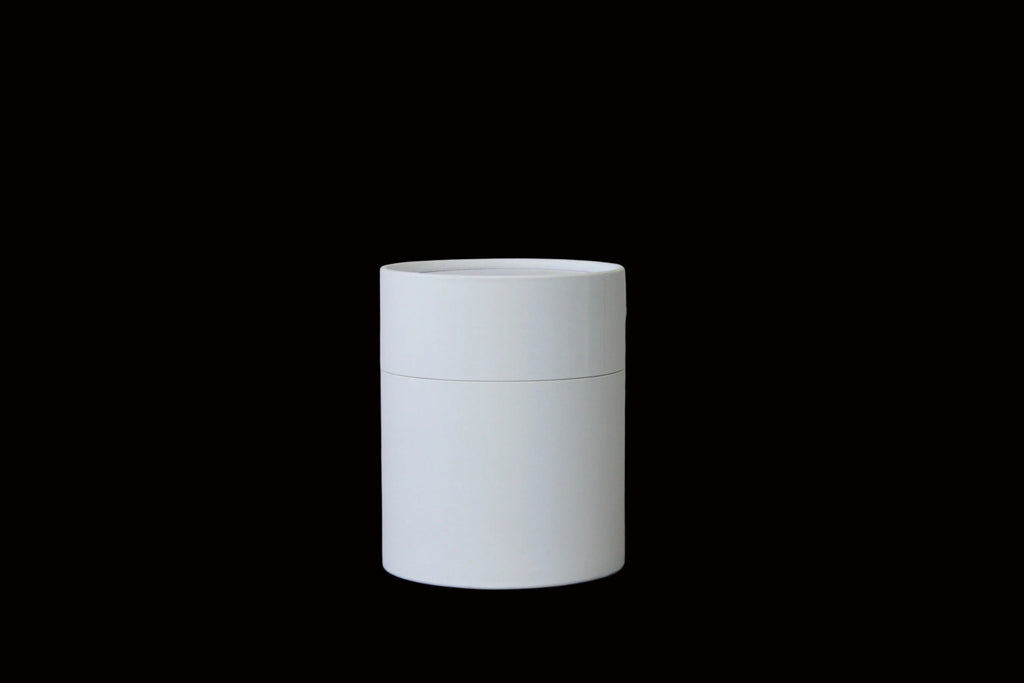 A minimalist white cylindrical container with a matching lid
