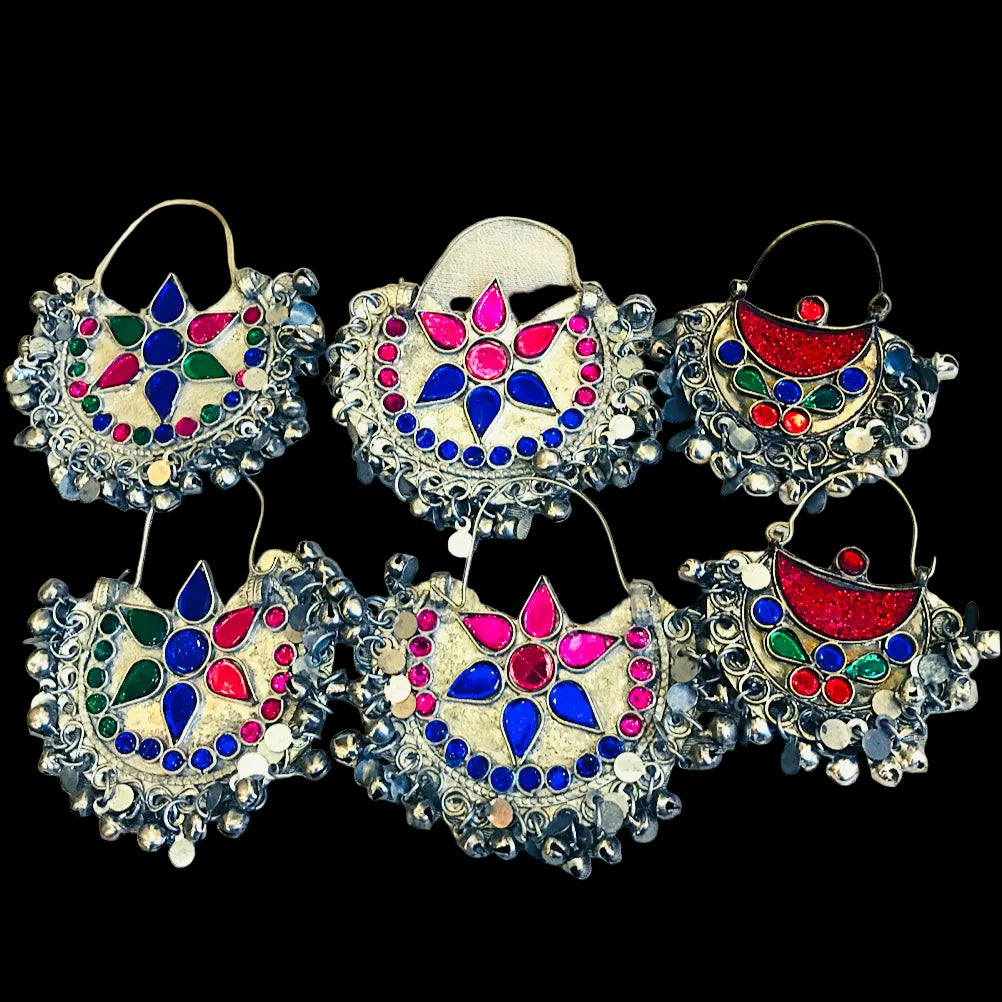A collection of six colorful glass gemstone and metal earrings with tribal style designs, displayed against a light background.